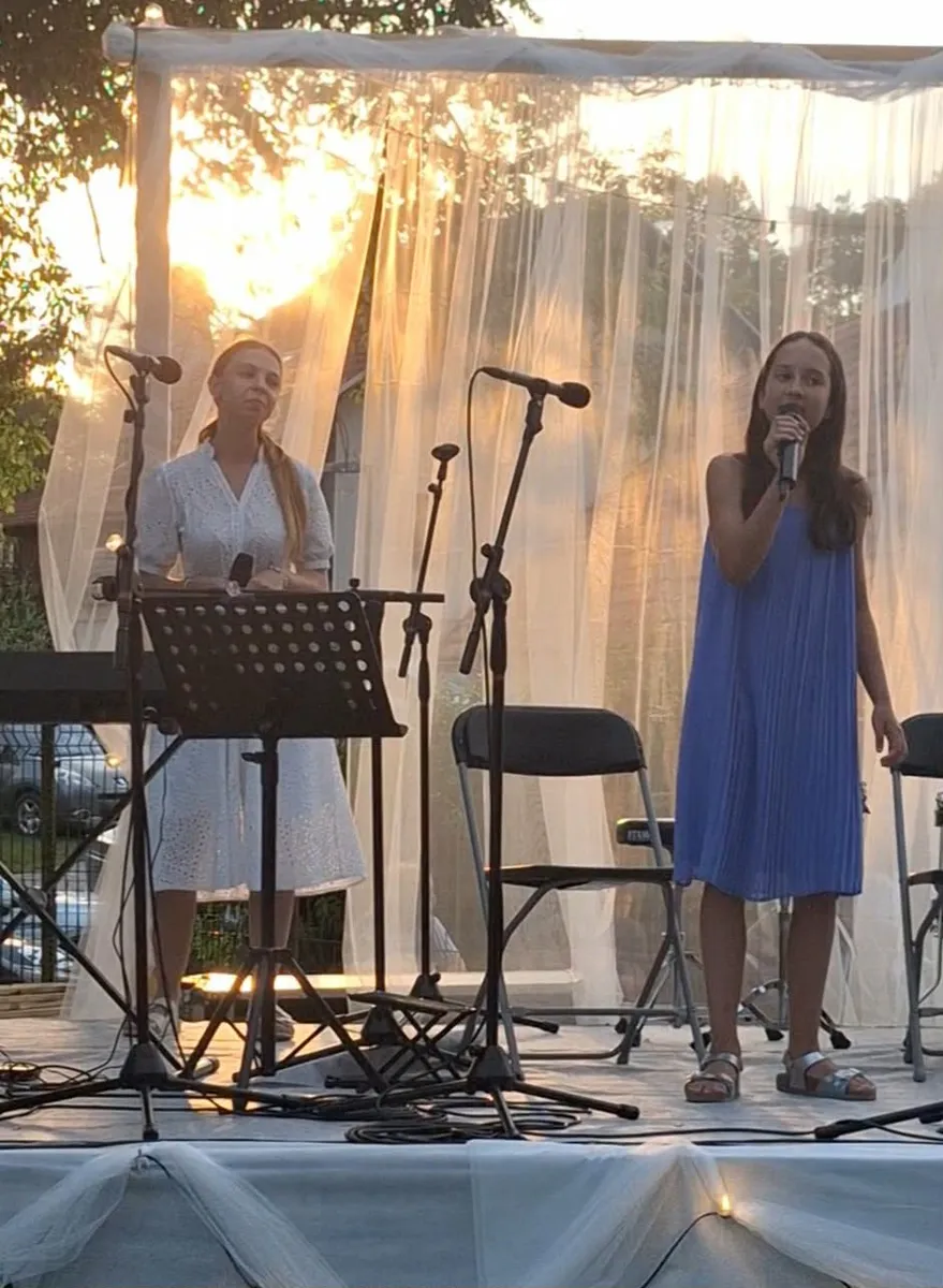 Pevski duet nastopa na odru na prostem.